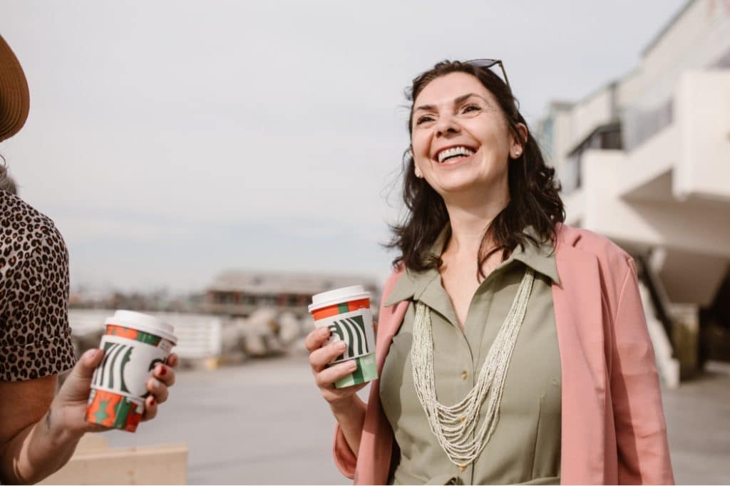 A woman enjoys a coffee with her friend, free from the shackles of bladder problems.